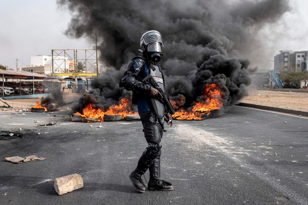 A Senegalese gendarme stand near a smoke billowing from burning tyres during a protest in Dakar on May 29, 2023, over the arrest of opposition leader Ousmane Sonko ahead of the final verdict in his rape trial/AFPpix