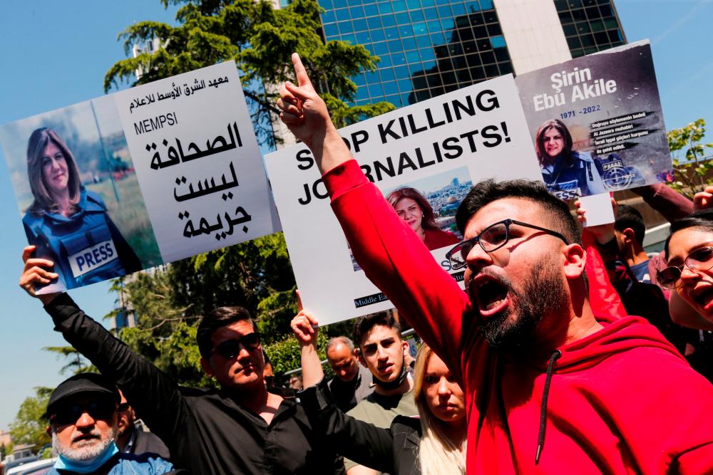 Pro-Palestinian demonstrators shout slogans as they hold placards with the pictures of Al Jazeera reporter Shireen Abu Akleh, who was killed during an Israeli raid in Jenin, during a protest outside the Israeli consulate in Istanbul, Turkey May 12, 2022. REUTERSpix