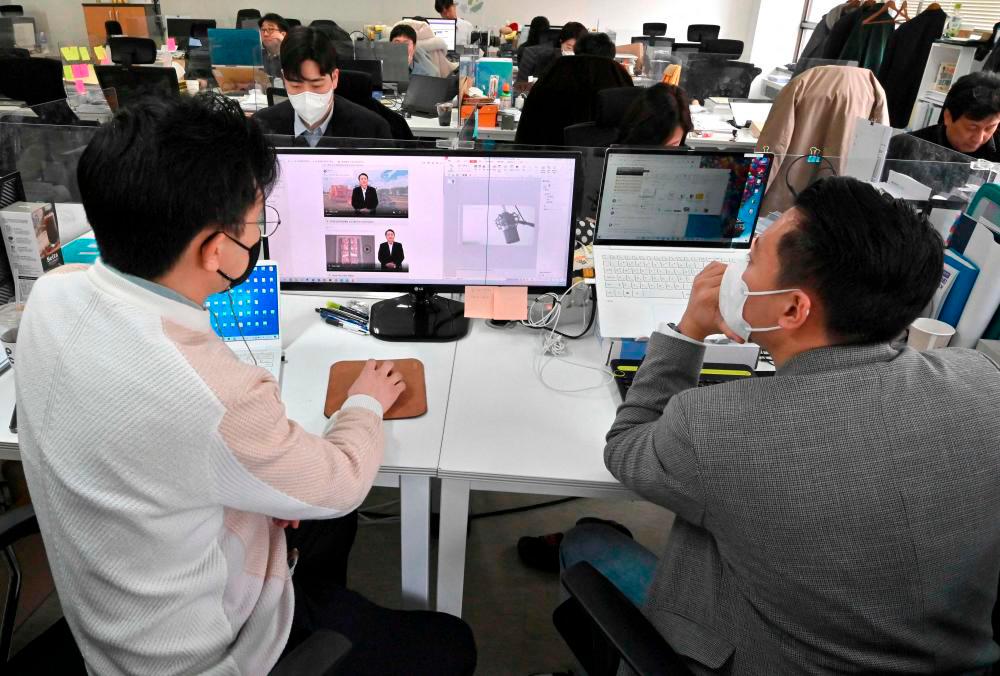 Baik Kyeong-hoon (L), director of the “AI Yoon” team, making a video clip using “AI Yoon”, a digital avatar of South Korean presidential candidate Yoon Suk-yeol of the opposition People Power Party, at an election campaign office in Seoul/AFPPix