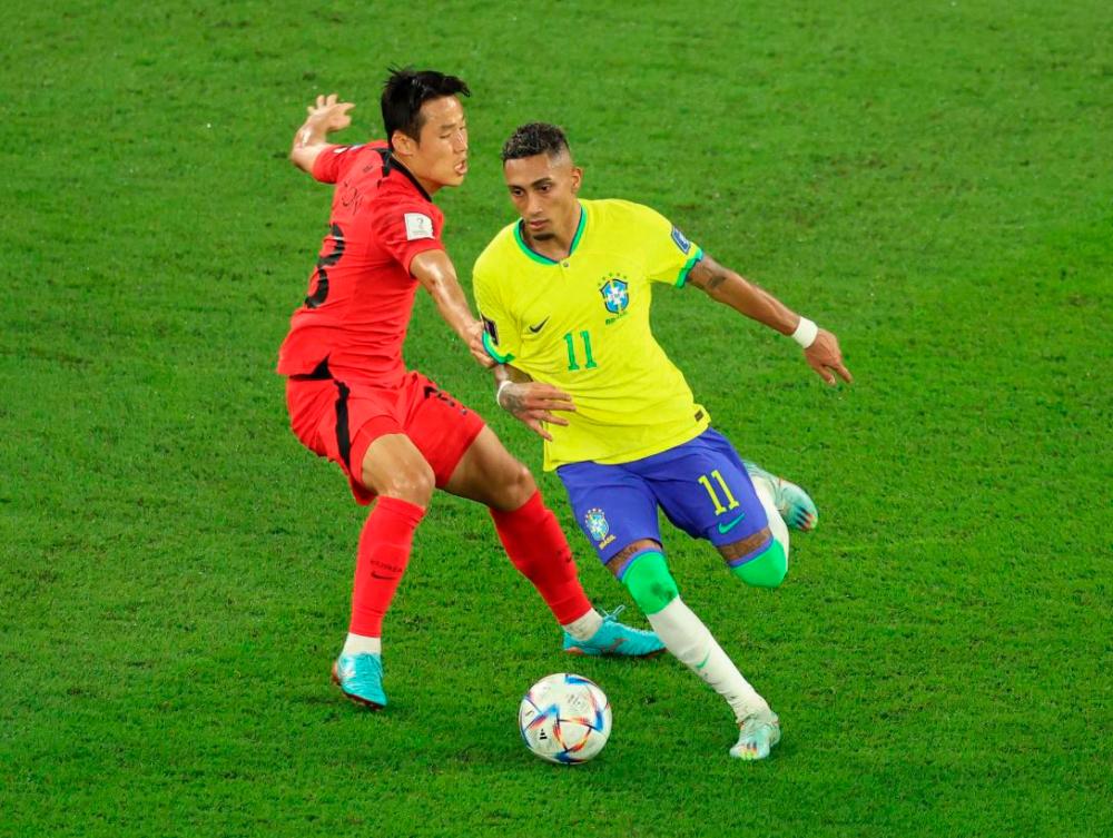 FIFA World Cup Qatar 2022 - Round of 16 - Brazil v South Korea - Stadium 974, Doha, Qatar - December 5, 2022. Raphinha in action with Son Jun-ho. REUTERSPIX