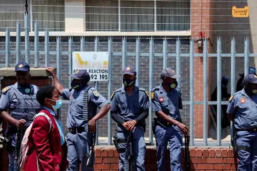 File photo: A student walks past police officers as they stand guard outside a school after an incident of alleged racism in Randfontein, west of Johannesburg, South Africa, February 14, 2022. REUTERSpix