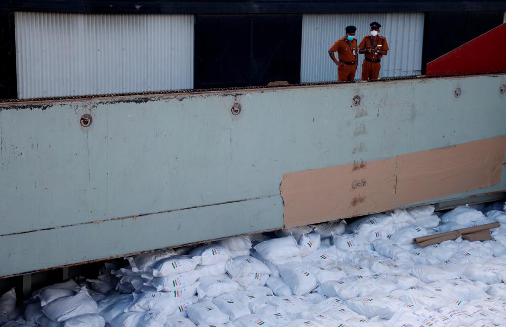 Members of security personnel stand on a cargo ship carrying essential supplies of rice, milk and some critically needed medicines from India, amid Sri Lanka's economic crisis, at a port in Colombo, Sri Lanka, May 22, 2022. Picture taken on May 22, 2022. REUTERSpix