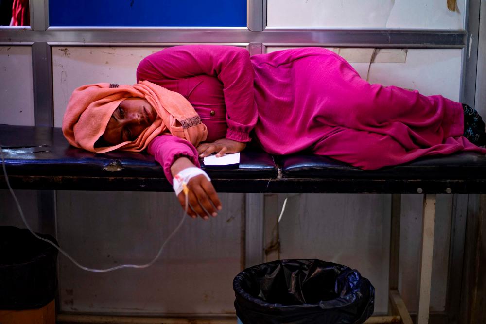 A woman suffering from cholera receives treatment at the Al-Kasrah hospital in Syria's eastern province of Deir Ezzor, on 17, 2022, affected by the usage of contaminated water from the Euphrates River, a major source for both drinking and irrigation. AFPPIX