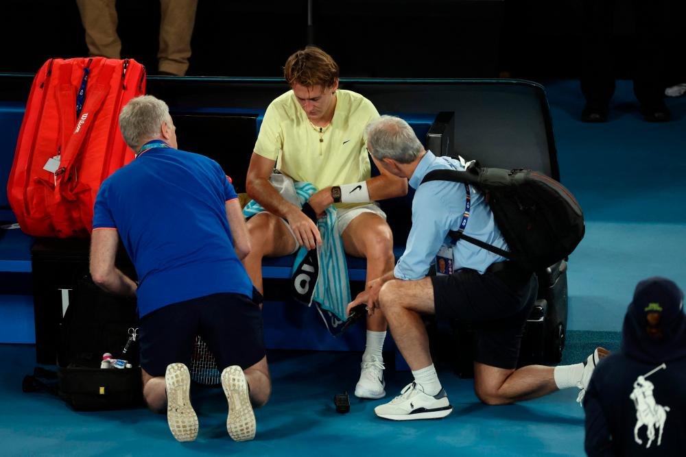 USA’s Sebastian Korda (C) talks with a physio as he pulls out of the match against Russia’s Karen Khachanov due to injury during their men’s singles quarter-final match on day nine of the Australian Open tennis tournament in Melbourne on January 24, 2023. AFPPIX
