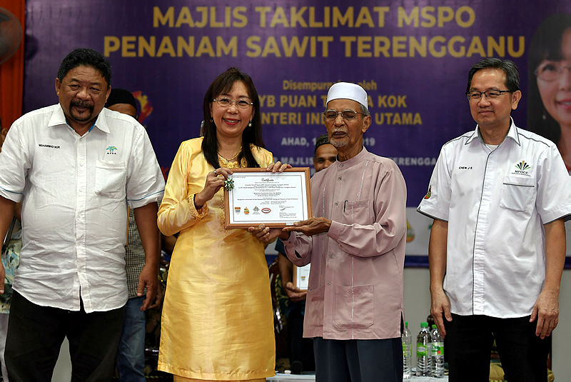 Primary Industries Minister Teresa Kok (2nd L) the Malaysian Sustainable Palm Oil (MSPO) certificate to, Sulong Muhamad, a smallholder in Terengganu, on Aug 18, 2019.