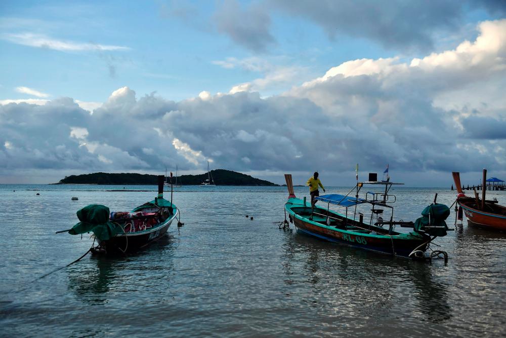 $!his photo taken on October 2, 2020 shows a Moken fisherman preparing fishing boats on the southern Thai island of Phuket. The COVID-19 coronavirus has wrought havoc across the world, but for Thailand’s “sea gypsies” it has brought welcome respite from the threat of mass tourism. / AFP / Lillian SUWANRUMPHA