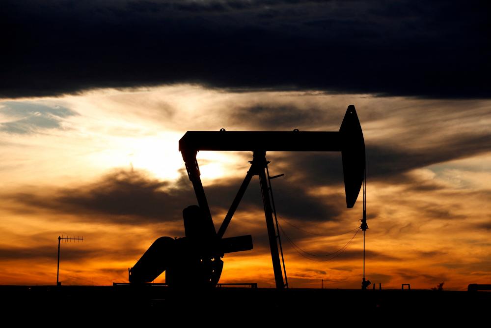 The sun sets behind a crude oil pump jack on a drill pad in the Permian Basin in Loving County, Texas. – Reuterspic