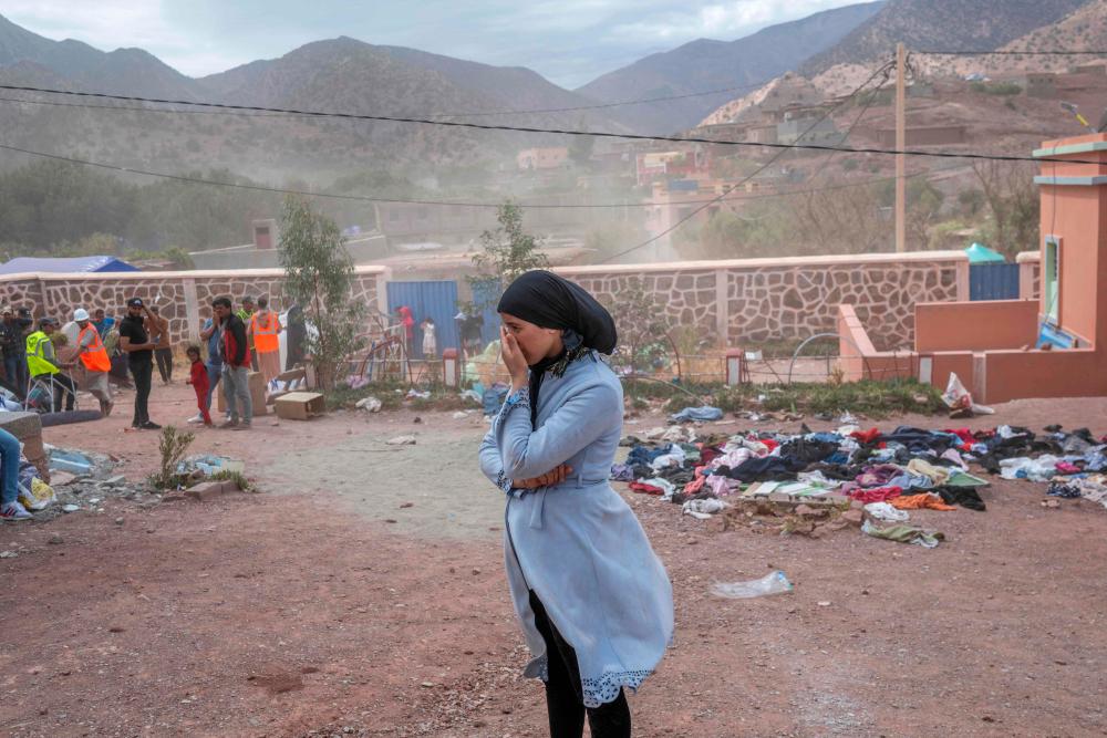 A woman waits to receive assistance in their village between Marrakech and Taroudant in the Atlas mountain range on September 17, 2023, in the aftermath of a powerful earthquake. AFPPIX