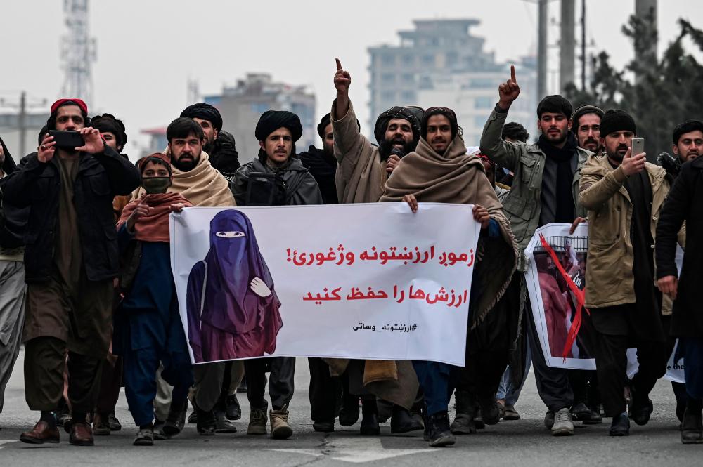 People march along a street while holding banners during a demonstration to condemn the recent protest by the Afghan women’s rights activists, in Kabul on January 21, 2022. AFPPIX