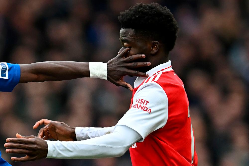 Everton's Senegalese midfielder Idrissa Gueye's finger gets into the eye of Arsenal's English midfielder Bukayo Saka (R) during the English Premier League football match between Everton and Arsenal at Goodison Park in Liverpool, north-west England, on February 4, 2023. AFPPIX