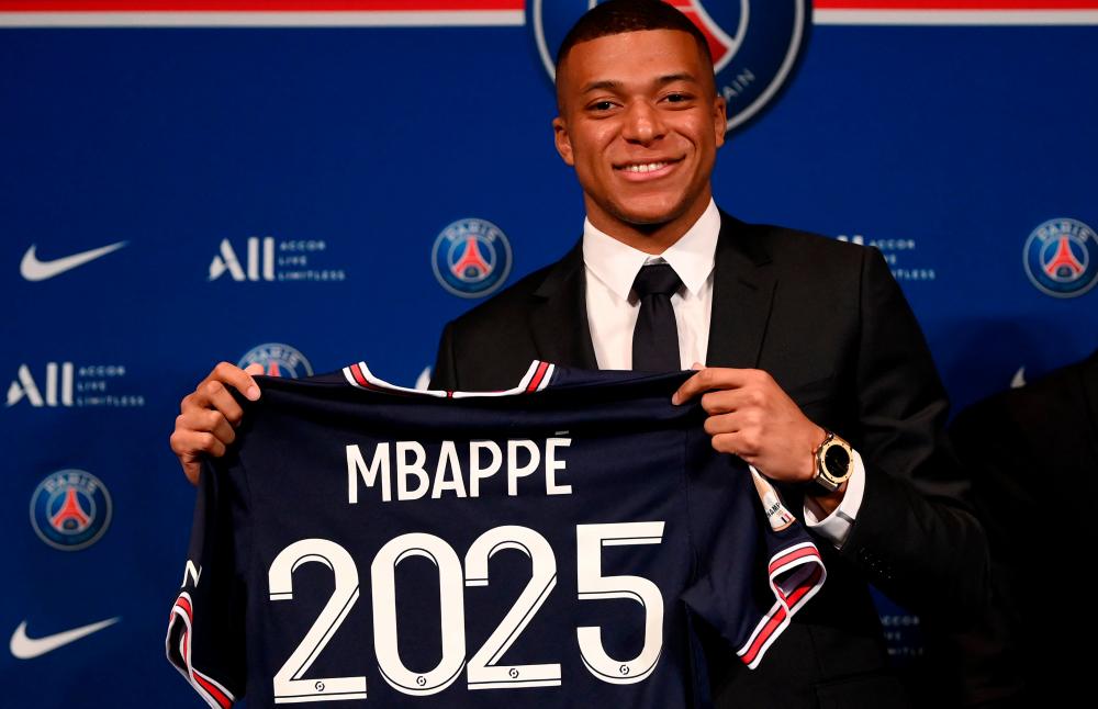 Paris Saint-Germain’s French forward Kylian Mbappe poses with a jersey at the end of a press conference at the Parc des Princes stadium in Paris on May 23, 2022, two days after the club won the Ligue 1 title for a record-equalling tenth time and its superstar striker Mbappe chose to sign a new contract until 2025 at PSG rather than join Real Madrid. AFPPIX