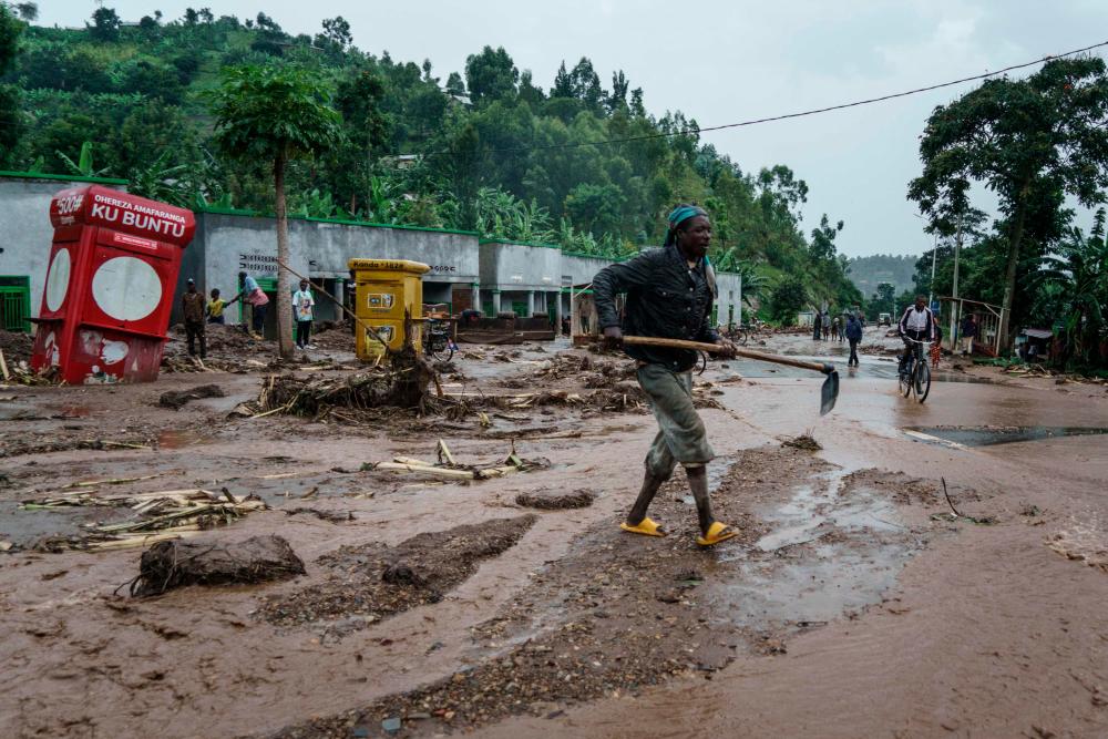 A man removes debris from the flooded road after the flood killed 10 people at the village of Bupfune near Kibuye, in Rwanda’s Western Province, on May 4, 2023. AFPPIX