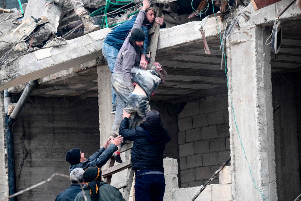 Residents retrieve an injured girl from the rubble of a collapsed building following an earthquake in the town of Jandaris, in the countryside of Syria’s northwestern city of Afrin in the rebel-held part of Aleppo province, on February 6, 2023. AFPPIX