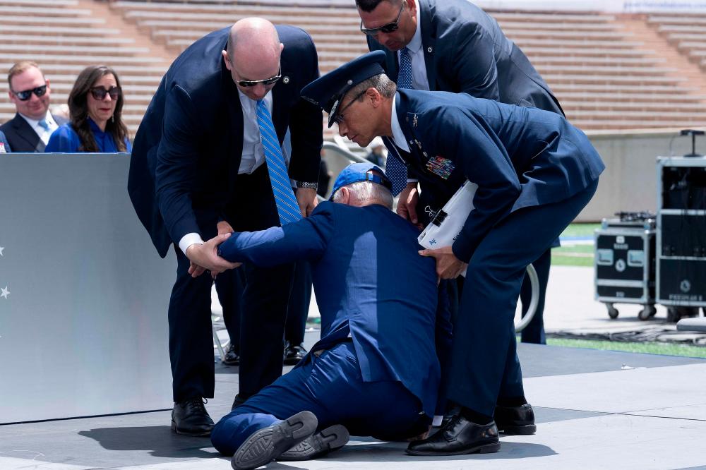 US President Joe Biden is helped up after falling during the graduation ceremony at the United States Air Force Academy, just north of Colorado Springs in El Paso County, Colorado, on June 1, 2023. AFPPIX