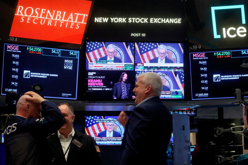 Traders react as Powell is seen delivering remarks on a screen, on the floor of the New York Stock Exchange on Wednesday, March 22, 2023. – Reuterspic