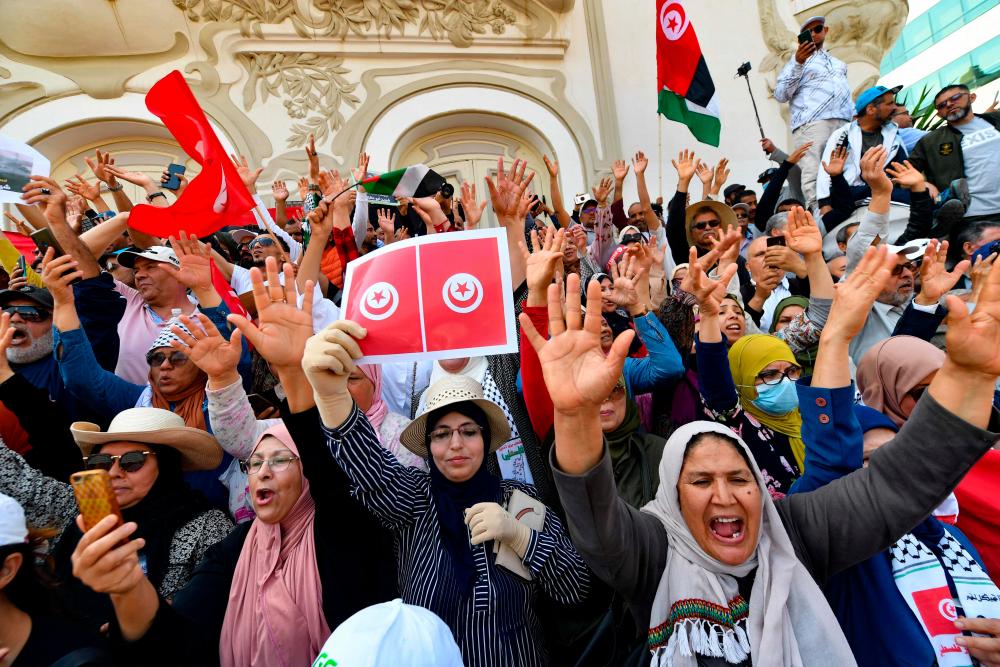 Tunisian protesters wave flags and shout slogans against their president, on May 15, 2022, during a demonstration in the capital Tunis. AFPPIX
