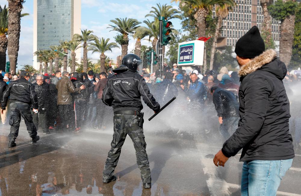 Demonstrators are hit by a water cannon during a protest against Tunisian President Kais Saied's seizure of governing powers, in Tunis, Tunisia/REUTERSPix