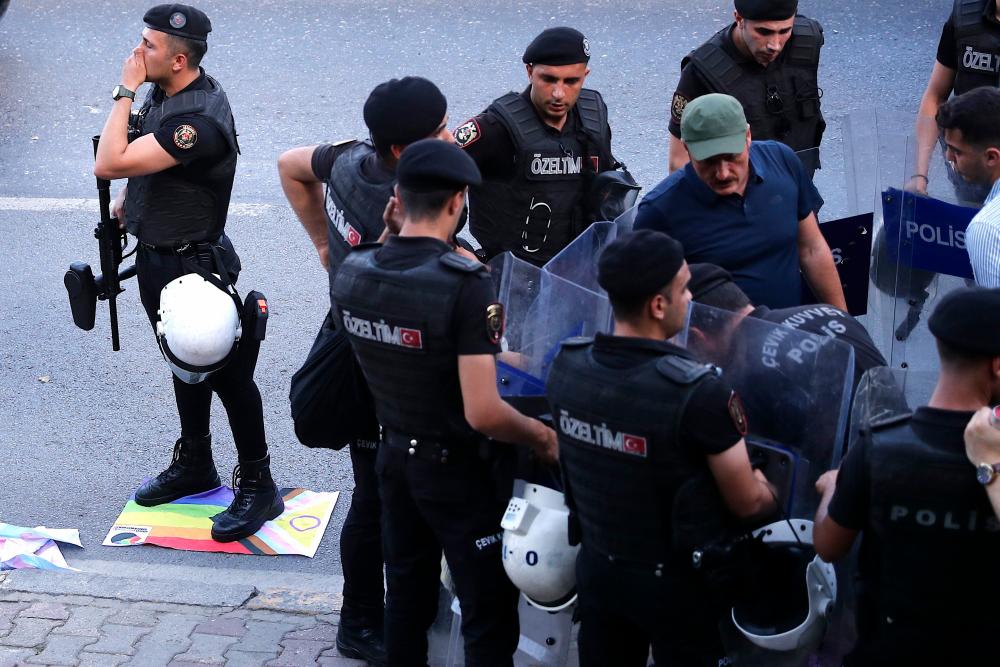 Turkish policeman gather as they detain a demonstrator during a Pride march in Istanbul, on June 26, 2022/AFPPix