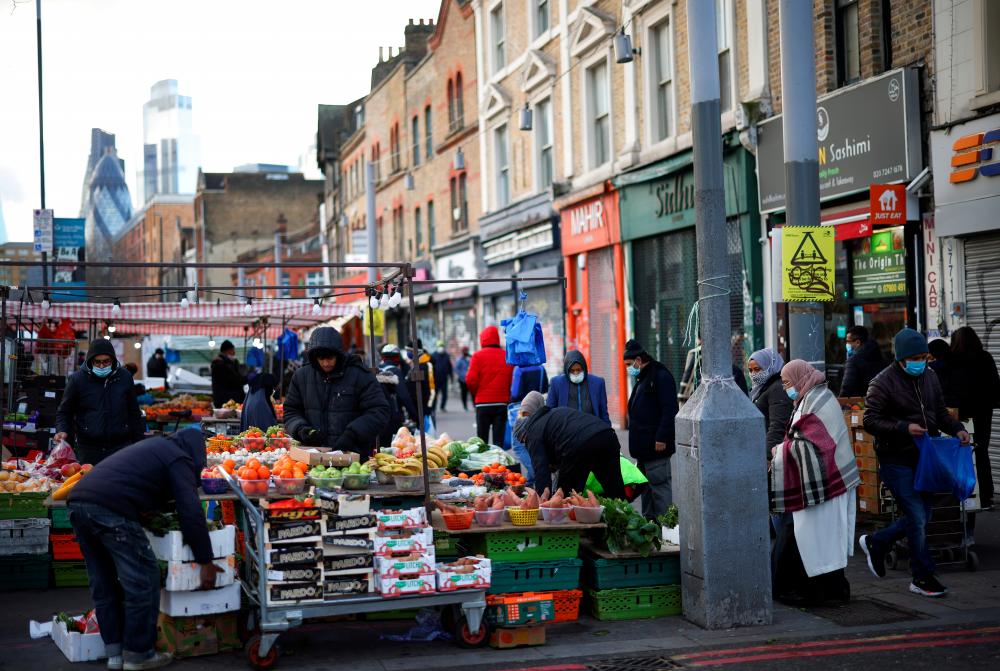 File photo: People shop at a market stalls in east London, Britain, January 23, 2021. REUTERSpix