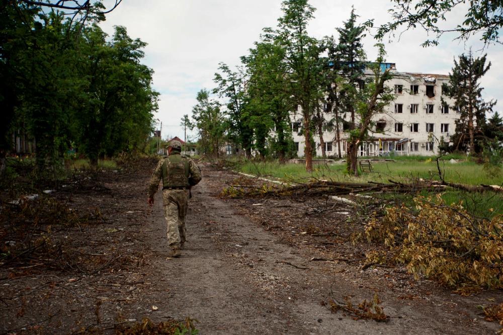 A Ukrainian serviceman inspects an area damaged by a Russian military strike, as Russia's attack on Ukraine continues, in the town of Marinka, in Donetsk region, Ukraine May 28, 2022. REUTERSpix