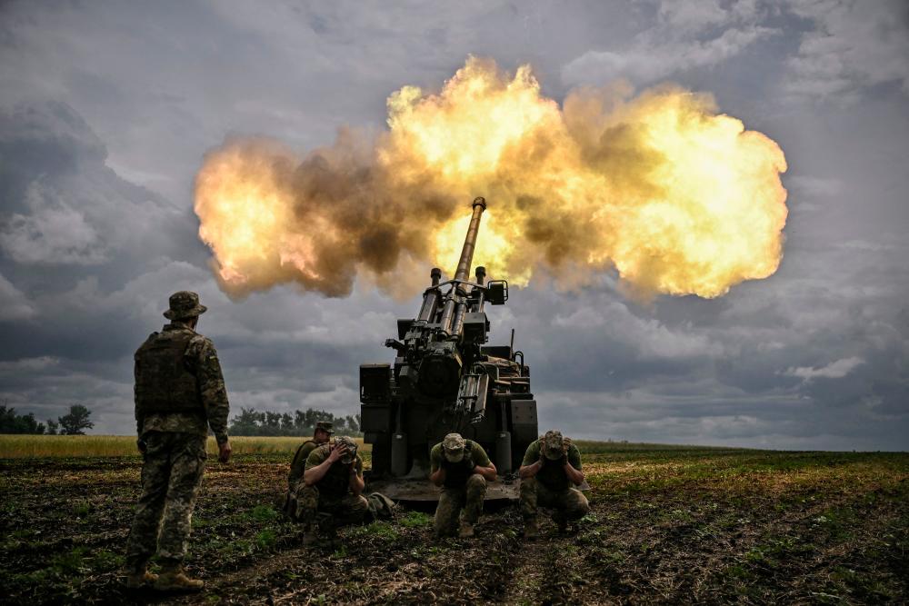 Ukrainian servicemen fire with a French self-propelled 155 mm/52-calibre gun Caesar towards Russian positions at a front line in the eastern Ukrainian region of Donbas on June 15, 2022. AFPPIX