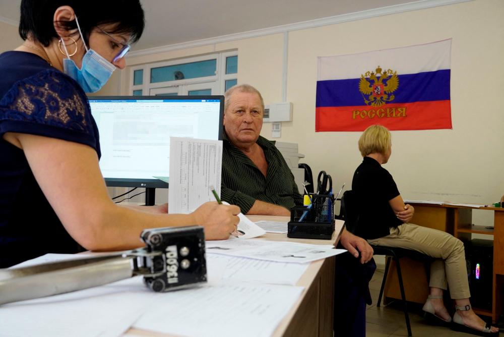 A man fills document to apply for new Russian passport at a centre in Melitopol in Zaporizhzhia region, on August 3, 2022, amid the ongoing Russian military action in Ukraine. AFPPIX