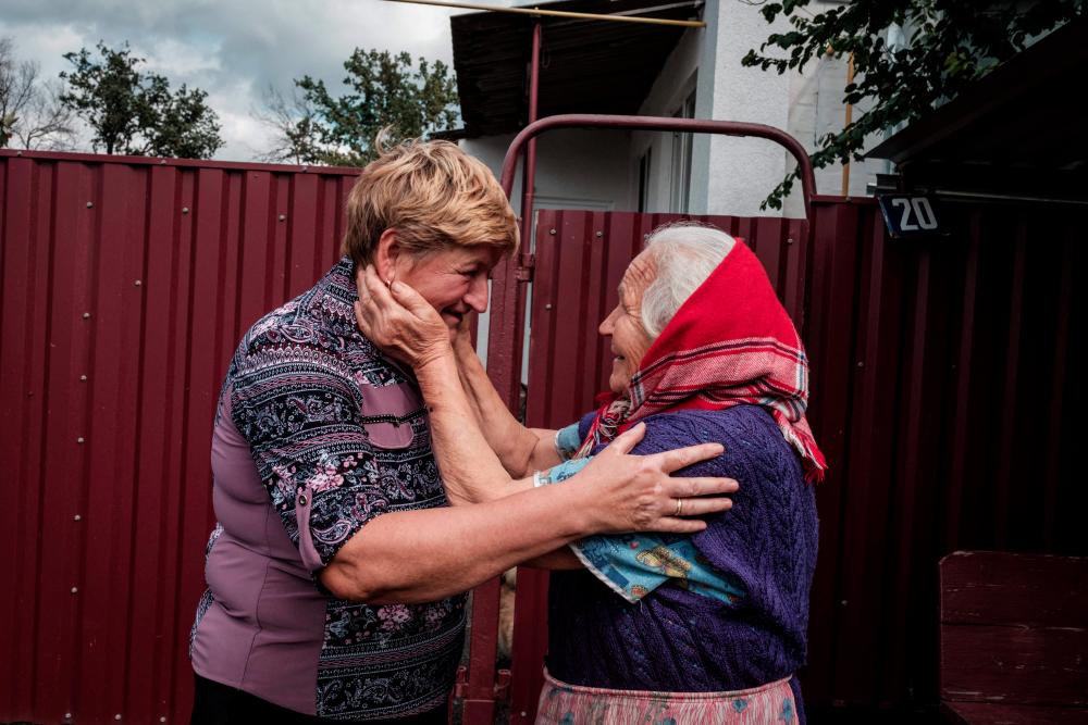 Olga Valkova (L), 64, meets her 80-year-old sister Garina Nazorenko as she returns to her liberated home village after six months and eleven days in Troitske, Kharkiv region, on September 18, 2022, amid Russian invasion of Ukraine. - AFPPIX