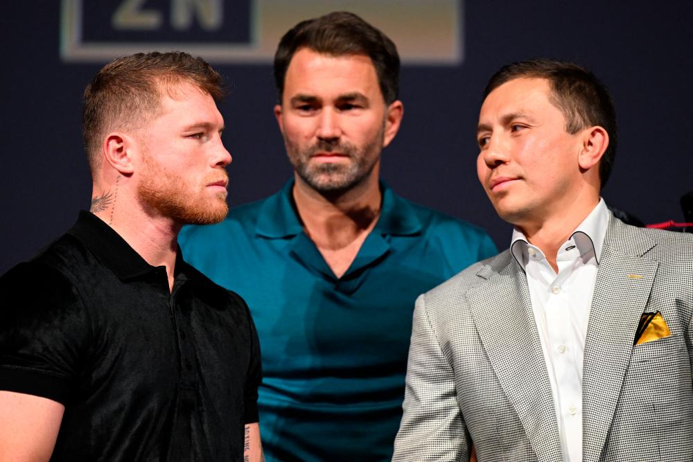 Mexican boxer Saul “Canelo” Alvarez (L) and Kazakhstani boxer Gennady Golovkin (R), alongside boxing promotor Eddie Hearn (C), pose for photos during a press conference ahead of their fight for the undisputed super middleweight championship of the world, in Hollywood, California on June 24, 2022. AFPPIX