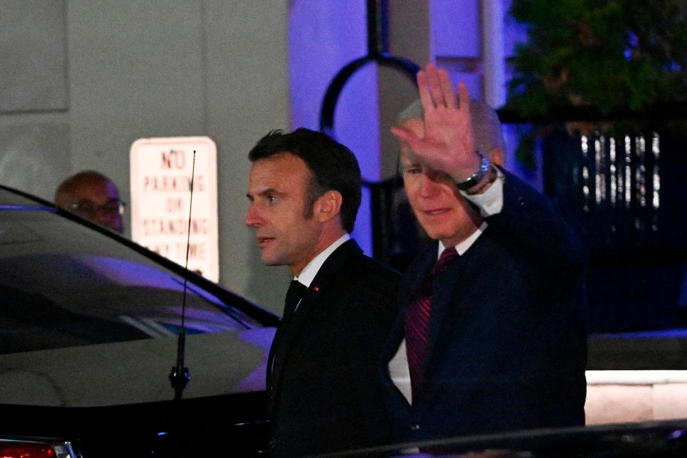 US President Joe Biden waves as he and French President Emmanuel Macron leave Fiola Mare restaurant after a private dinner in Washington, DC, on November 30, 2022. AFPPIX