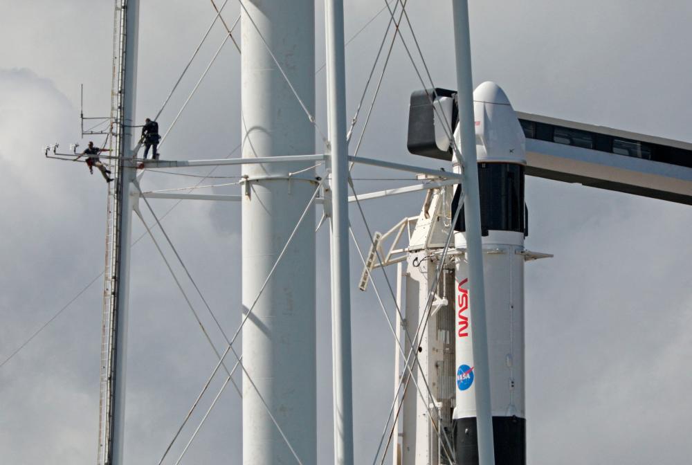 Workers are seen atop a water tower adjacent to the SpaceX Falcon 9 rocket at launch complex 39A one day before the Crew-5 mission at the Kennedy Space Center in Florida on October 5, 2022. AFPPIX