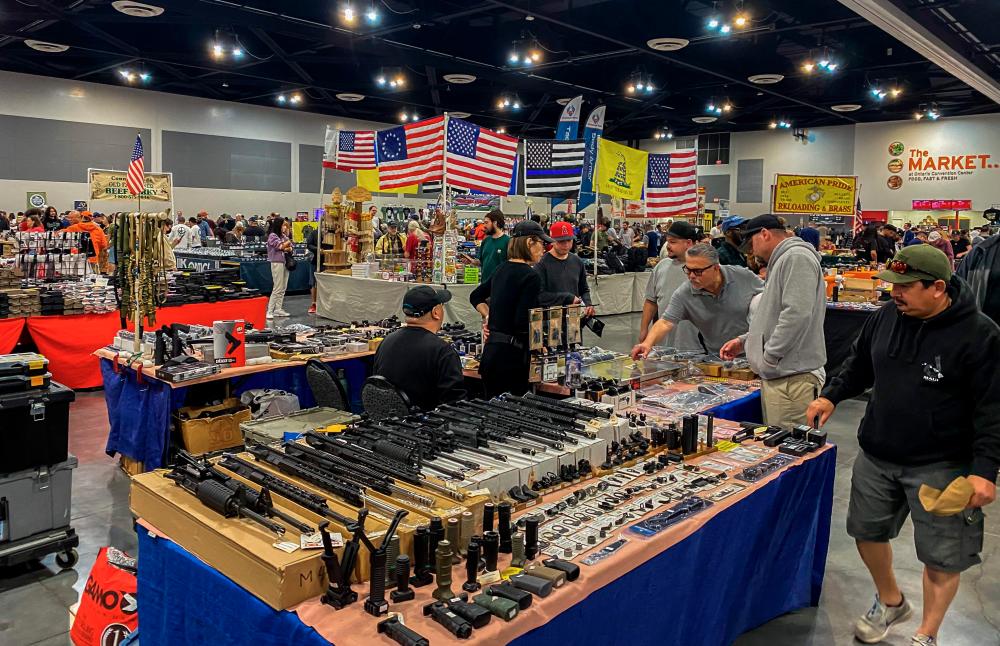 Men browse as vendors sell firearms and accessories at the Crossroads of the West Gun Show at the Convention Center in Ontario, California, on January 28, 2023. AFPPIX