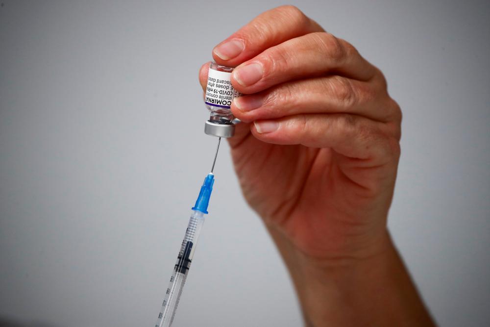 FILE PHOTO: A medical worker prepares a dose of the Comirnaty Pfizer-BioNTech Covid-19 vaccine at a coronavirus disease (Covid-19) vaccination center in Madrid, Spain, November 24, 2021. REUTERSpix