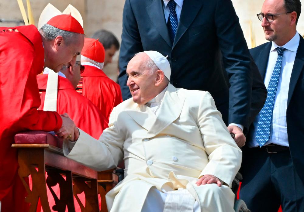 Pope Francis, seated in his wheelchair, goes to salute Cardinals and Bishops at the end of the Palm Sunday mass on April 2, 2023 at St. Peter’s square in The Vatican. AFPPIX