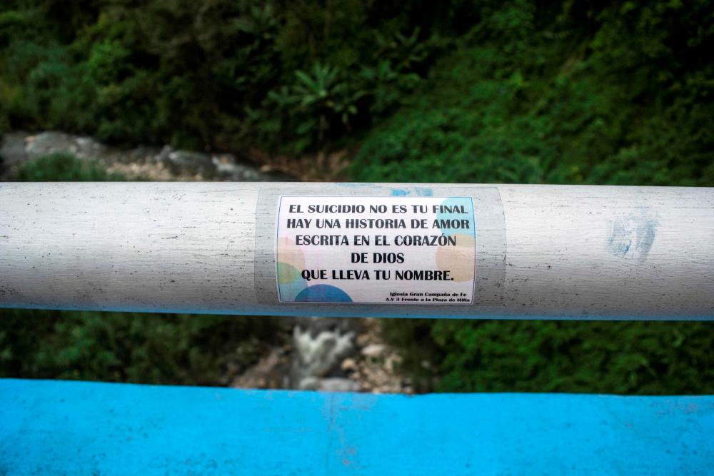 View of a sticker with a religious message which calls for reflection so as not to carry on with suicide, placed at the Miranda viaduct bridge, considered high-risk due to the many suicides committed there, in Merida, Merida state, Venezuela on August 3, 2022. AFPPIX