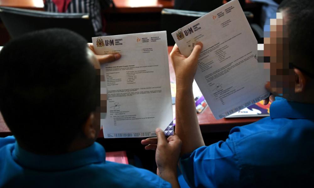 The two inmates, Jep, 36 and Ken, 34 showing off their offer letters to continue their postgraduate studies at Universiti Sains Malaysia (USM). — Bernama