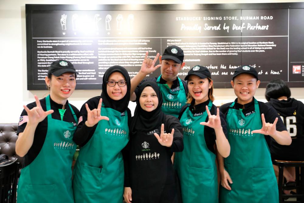 Mei (far right) with her colleagues at the Starbucks Signing Store in Burmah Road, Penang.