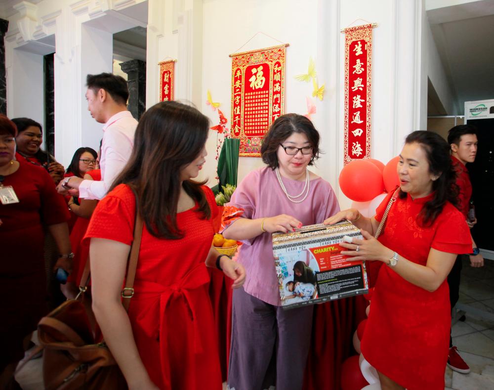 Lau with the donation box at the Chinese New Year luncheon.